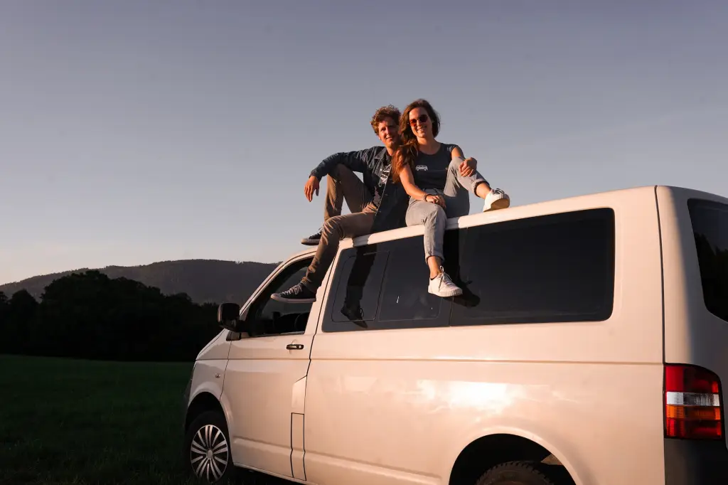Das Foto zeigt Laura und Michi von einfach-herumgurken auf ihrem alten VW T5. Sie beschreiben auf dieser Seite den Ausbau dieses Transporters zum vollwertigen Camper.