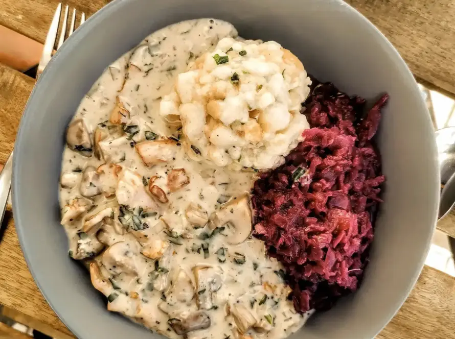 Das Bild zeigt ein Teller mit veganer Eierschwammerlsoße, Blaukraut und Semmelknödel. Ein typisch österreichisches Herbstgericht von einfach-herumgurken.